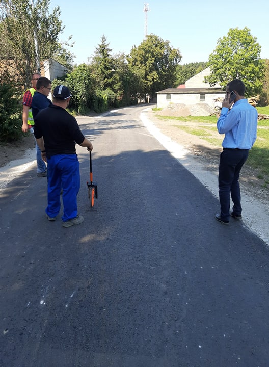 Na zdjęciach widać nowo wybudowaną drogę, a w trakcie odbioru końcowego inwestycji przy udziale przedstawicieli wykonawcy i zamawiającego oraz w kolejnych dniach.